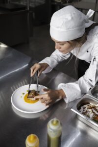 female-chef-kitchen-preparing-plate-steak